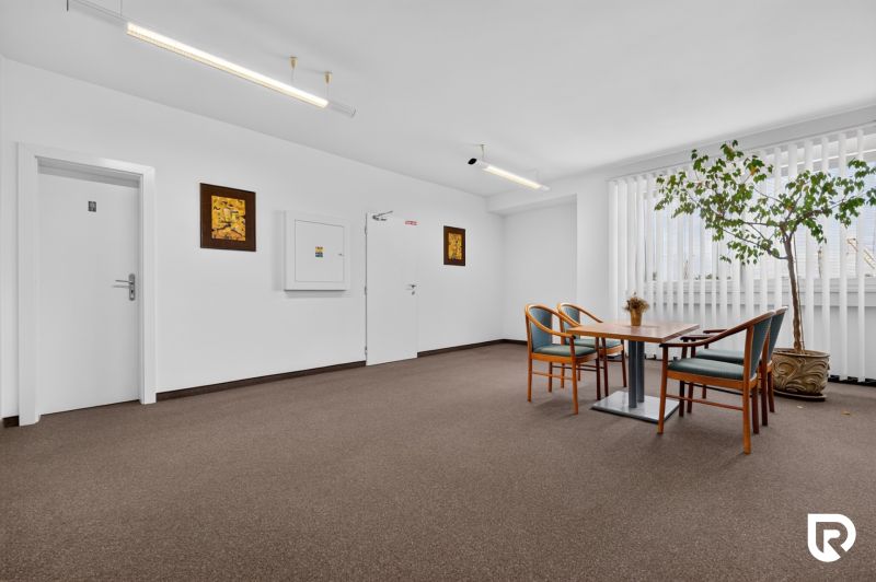 Prenájom 36m2 kancelárie | ul. Brnianska | Trenčín - Kancelárie so stolom a stoličkami, koberec, interiérová rastlina, dekoratívne obrazy.