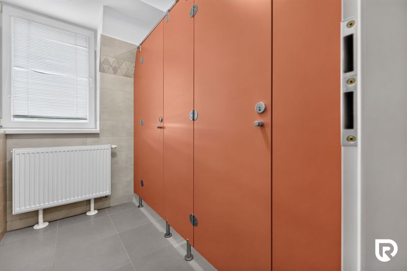 Prenájom 36m2 kancelárie | ul. Brnianska | Trenčín - Oranžové kabínky s dvierkami na verejných toaletách v kanceláriách.