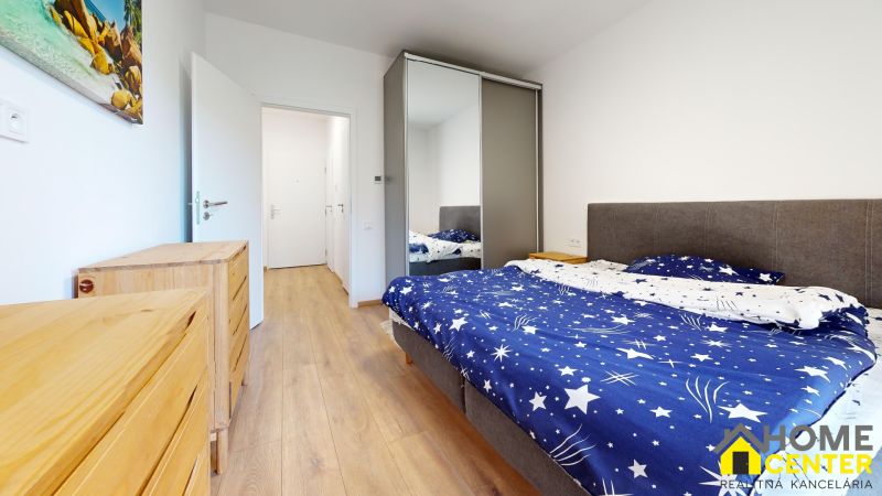 PRENÁJOM 2 izbový, zariadený byt v Danube residencia - REZERVOVANÉ - Spálňa s posteľou, vstavanou skriňou a podlahou s dreveným dekorom v 2-izbovom byte.