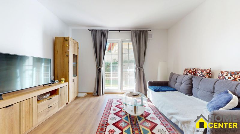 PRENÁJOM 2 izbový, zariadený byt v Danube residencia - REZERVOVANÉ - Obývačka 2-izbového bytu s pohovkou, televízorom a podlahou s dreveným dekorom.