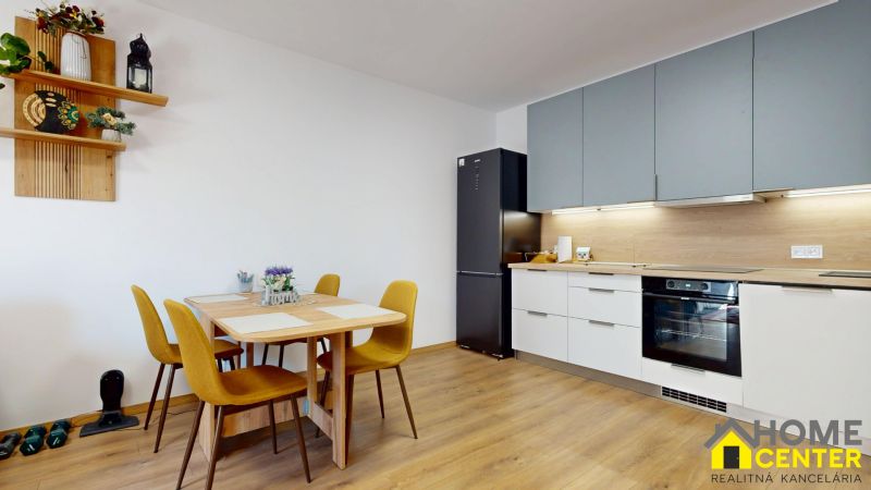 PRENÁJOM 2 izbový, zariadený byt v Danube residencia - REZERVOVANÉ - Kuchyňa v 2-izbovom byte s podlahou s dreveným dekorom, jedálenským stolom a spotrebičmi.
