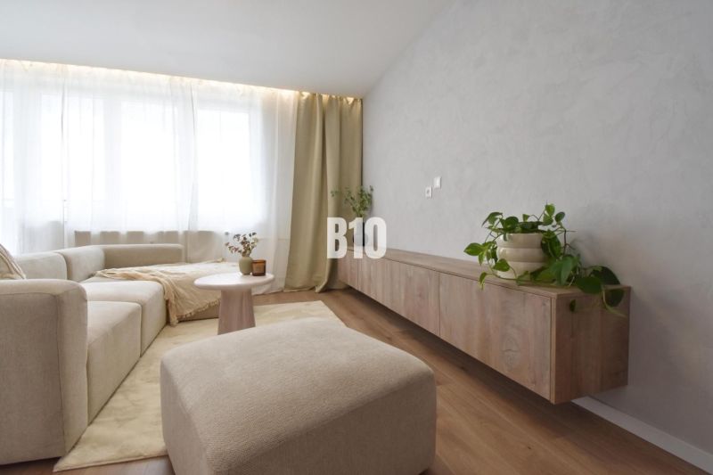 Rezervované-BÔRIK - 4-izbový BYT S GARÁŽOU - Pohodlná obývačka so svetlou sedačkou, podlaha s dreveným dekorom, 4-izbový byt.