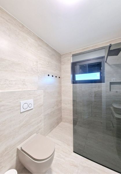 CHORVÁTSKO - Zariadený 3 izbový byt - PRIVLAKA, ZADAR - Kúpeľňa v 3-izbovom byte s keramickými obkladmi a sklenenou stenou sprchového kúta.
