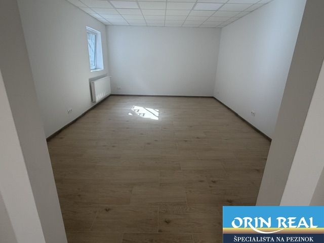 Na prenájom obchodný priestor v centre Pezinka 100m2 - Obchodné priestory s podlahou s dreveným dekorom, svetločervené steny, malé okno.