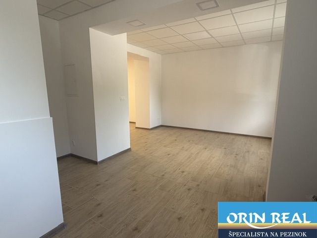 Na prenájom obchodný priestor v centre Pezinka 100m2 - Obchodné priestory s bielymi stenami a podlahou s dreveným dekorom.
