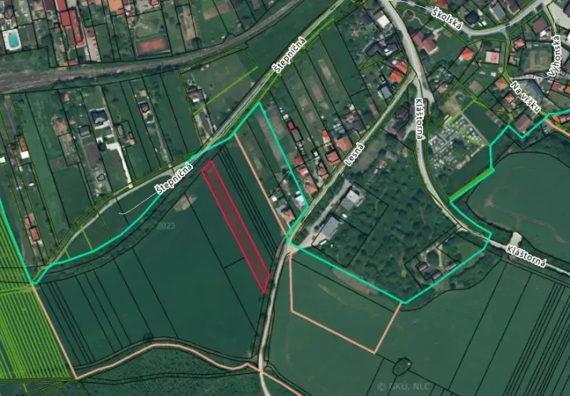 Podhájska - 2.084 m2 POZEMOK na okraji obce - Letecký pohľad na poľnohospodárske a lesné pozemky v Podhájskej s viditeľnou cestnou sieťou.