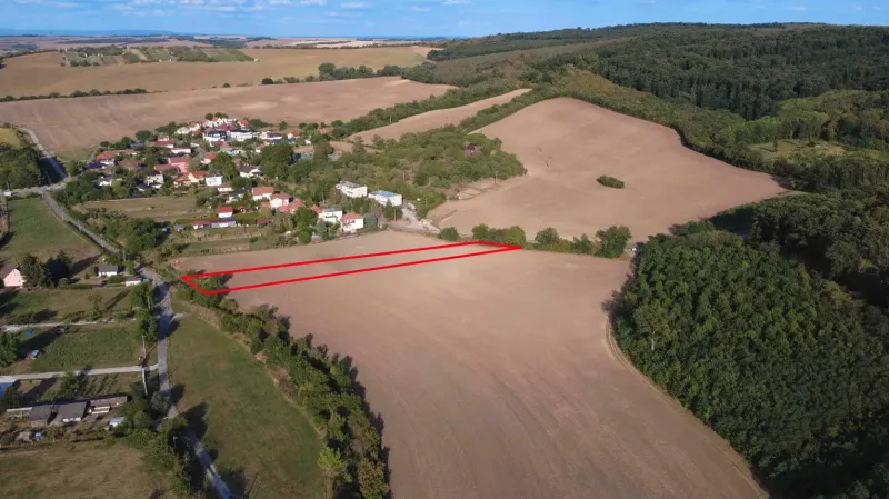 Podhájska - 2.084 m2 POZEMOK na okraji obce - Letecký pohľad na poľnohospodárske a lesné pozemky pri Podhájskej obkolesené obcou a lesom.