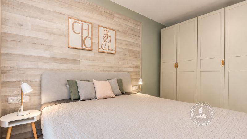 2-izbový byt s PARKOVACÍM MIESTOM lokalita CHOPOK JUH - Spálňa v 2-izbovom byte s podlahou s dreveným dekorom, svietidlami a vstavanou skriňou.