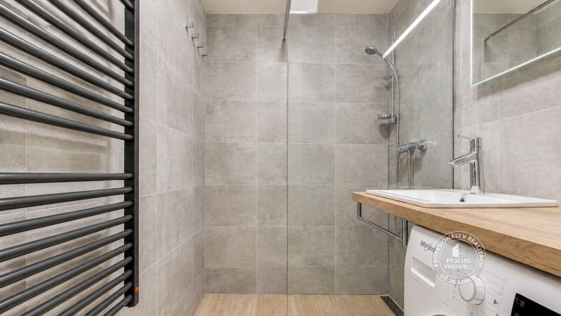 2-izbový byt s PARKOVACÍM MIESTOM lokalita CHOPOK JUH - Moderná kúpeľňa so sprchovacím kútom a podlahou s dreveným dekorom v 2-izbovom byte.