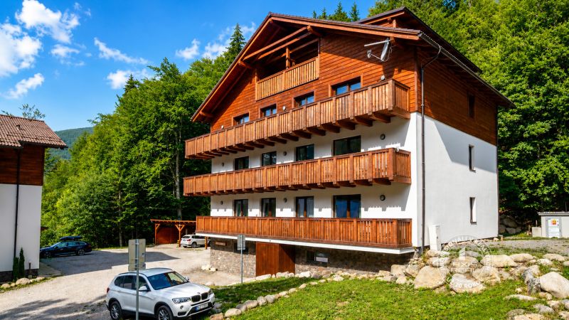 2-izbový byt s PARKOVACÍM MIESTOM lokalita CHOPOK JUH - Exteriér budovy s drevenými balkónmi v Bystrej, vhodné pre 2-izbový byt.