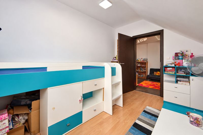 Predaj 4i dom, 52 m2 garáž, 518 m2 pozemok, Mosonmagyaróvár - Detská izba v rodinnom dome s pestrofarebným nábytkom a podlahou s dreveným dekorom.