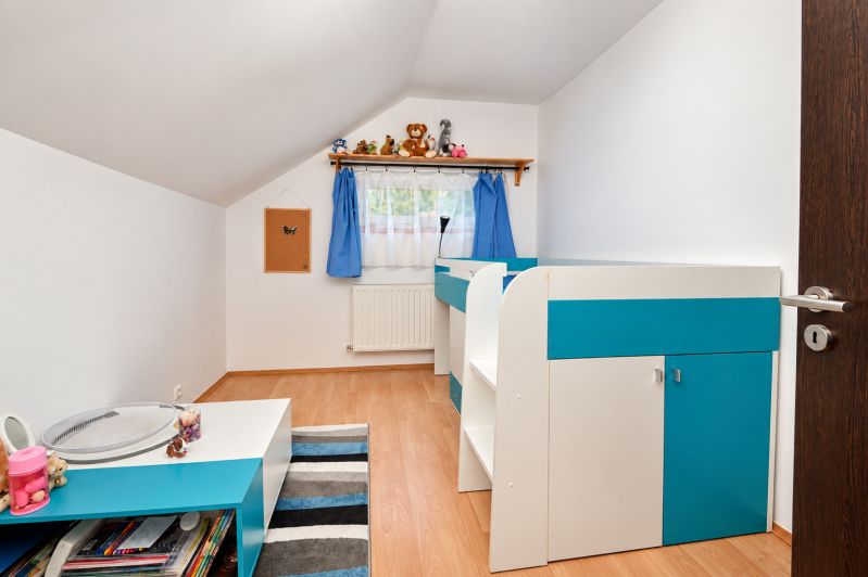 Predaj 4i dom, 52 m2 garáž, 518 m2 pozemok, Mosonmagyaróvár - Detská izba v rodinnom dome s modrou dekoráciou a podlahou s dreveným dekorom.