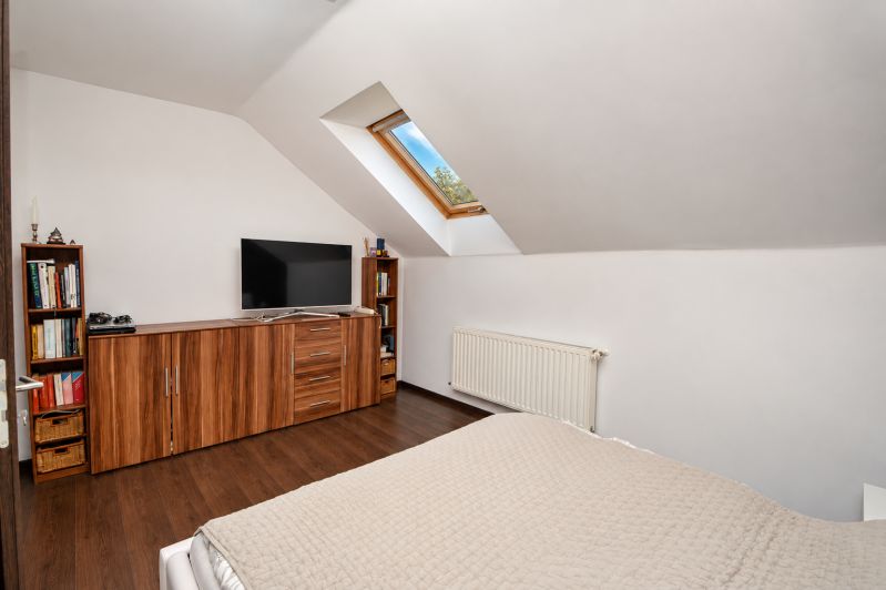 Predaj 4i dom, 52 m2 garáž, 518 m2 pozemok, Mosonmagyaróvár - Podkrovná spálňa s podlahou s dreveným dekorom v rodinnom dome.