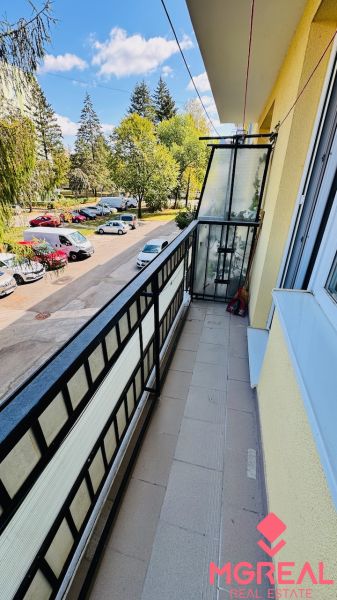 Na predaj 3 i byt 73 m2 s loggiou Partizánske – balkón, komora, špajza - Balkón s výhľadom na stromy a autá na Nádražnej v Partizánskom, priestor 3-izbového bytu.