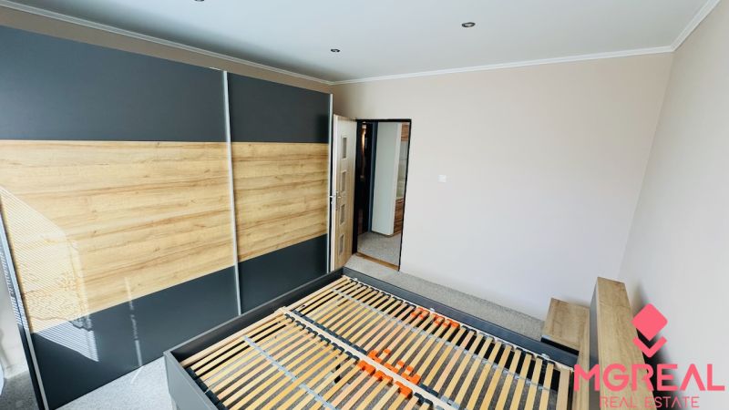 Na predaj 3 i byt 73 m2 s loggiou Partizánske – balkón, komora, špajza - Spálňa so vstavanou skriňou a posteľou v 3-izbovom byte s podlahou s dreveným dekorom.