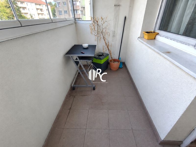 REZERVOVANÉ Na predaj 1 izbový byt Martin – Podháj, ulica Timravy - Balkón 1-izbového bytu s dlažbou, stolíkom a kvetináčmi.