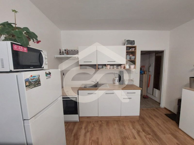 KOMPLETNE PREROBENÁ GARSÓNKA + PIVNICA: Nitra – Chrenová !  - Kuchyňa v garsónke s mikrovlnkou, chladničkou a podlahou s dreveným dekorom.
