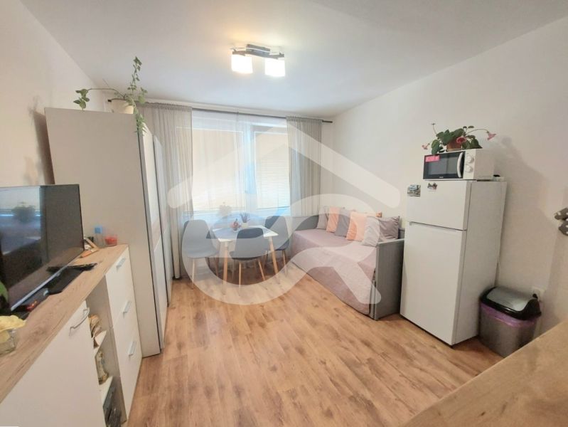 KOMPLETNE PREROBENÁ GARSÓNKA + PIVNICA: Nitra – Chrenová !  - Garsónka s podlahou s dreveným dekorom, stolom so stoličkami a pohovkou.
