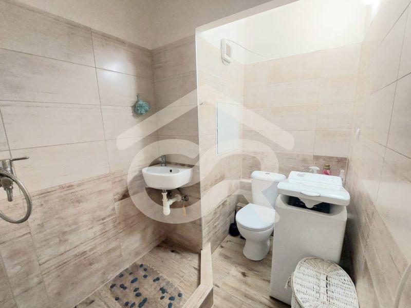 KOMPLETNE PREROBENÁ GARSÓNKA + PIVNICA: Nitra – Chrenová !  - Kúpeľňa v garsónke s toaletou, umývadlom a práčkou; podlaha s dreveným dekorom.