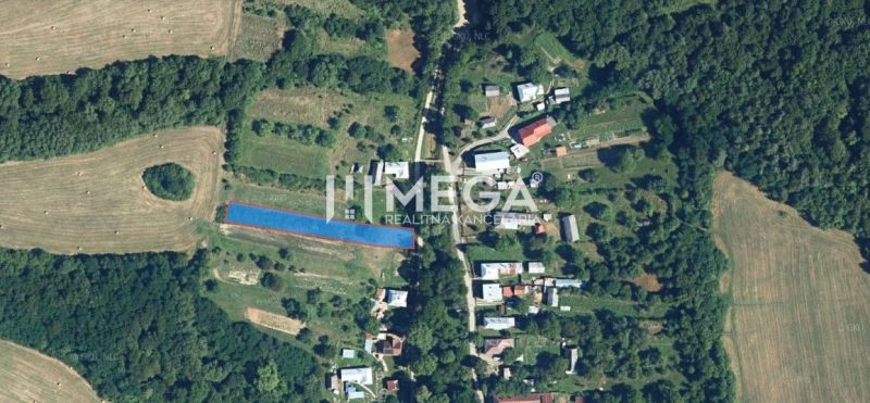 Na predaj pozemok aj na výstavbu v obci Vyšné Ladičkovce - Letecký pohľad na pozemky pre bývanie vo Vyšných Ladičkovciach obklopené políčkami a lesom.