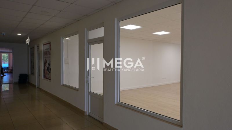 PRENÁJOM OBCHODNÉHO PRIESTORU (54 m2) ulica MIEROVÁ HUMENNÉ - Interiér obchodných priestorov s podlahou s dreveným dekorom a veľkými presklenými oknami.