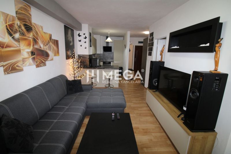 REZERVOVANÝ - Na predaj moderný 2-izbový byt po rekonštrukcii - Obývačka v 2-izbovom byte s rohovou sedačkou a podlahou s dreveným dekorom.