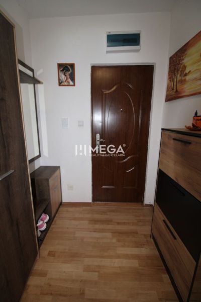 REZERVOVANÝ - Na predaj moderný 2-izbový byt po rekonštrukcii - Chodba v 2-izbovom byte s podlahou s dreveným dekorom a tmavým nábytkom.