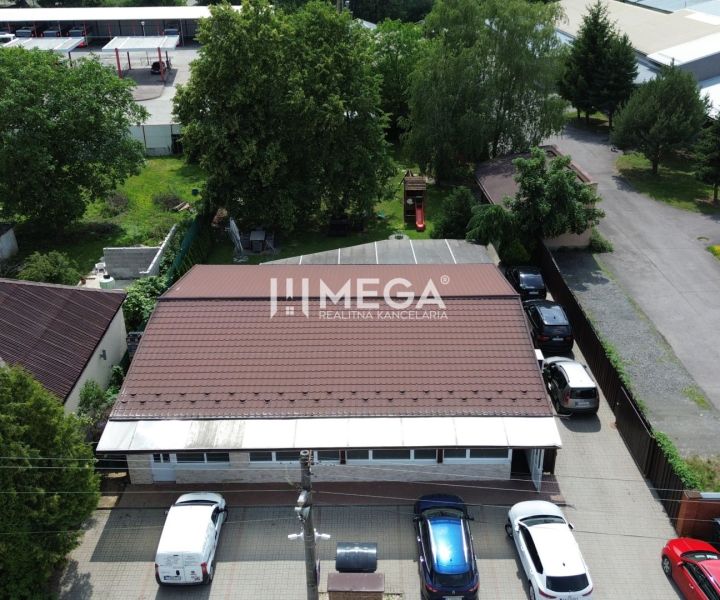 NA PREDAJ PRÉMIOVÉ OBCHODNÉ PRIESTORY REŠTAURÁCIA BARÓNKA VT - Gastro priestory na Budovateľskej ulici vo Vranove nad Topľou obklopené autami a zeleňou.