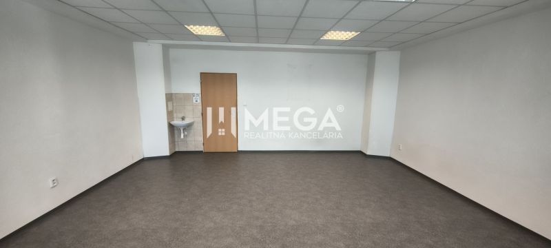 NA PRENÁJOM KANCELÁRIA IDEÁLNA NA SLUŽBY 35m² - HUMENNÉ - Prázdne kancelárske priestory s umývadlom a tmavou podlahou s dreveným dekorom.