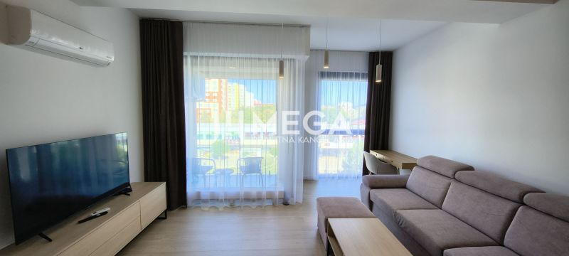 NA PRENÁJOM PRÉMIOVÝ 3-IZBOVÝ BYT – CENTRAL POINT HUMENNÉ - Obývacia izba v 3-izbovom byte s pohodlnou sedačkou a veľkými oknami.