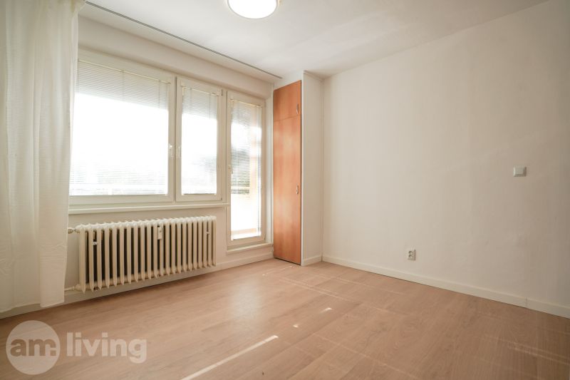 REZERVOVANÉ 1 izbový byt s balkónom - až 41m² N. DUBNICA - Izba v 1-izbovom byte s podlahou s dreveným dekorom, bielymi stenami a oknami.