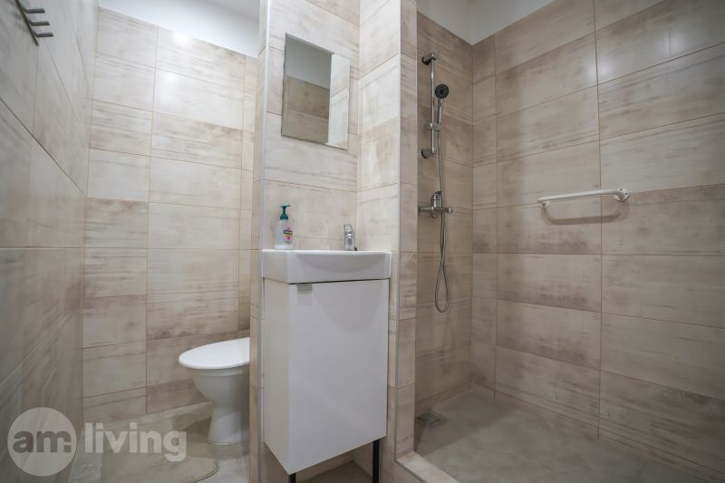 REZERVOVANÉ 1 izbový byt s balkónom - až 41m² N. DUBNICA - Kúpeľňa v 1-izbovom byte s umývadlom, sprchou a béžovým obkladom.