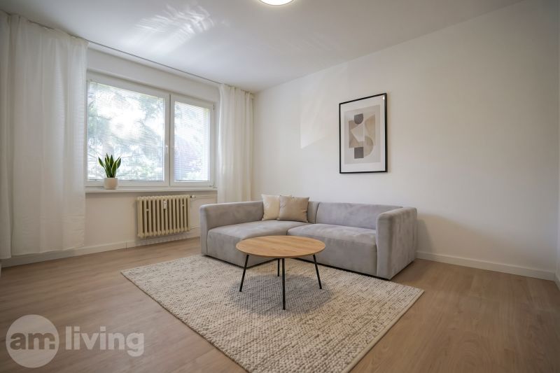 REZERVOVANÉ 1 izbový byt s balkónom - až 41m² N. DUBNICA - Obývačka v 1-izbovom byte s pohovkou, koberec a podlaha s dreveným dekorom.