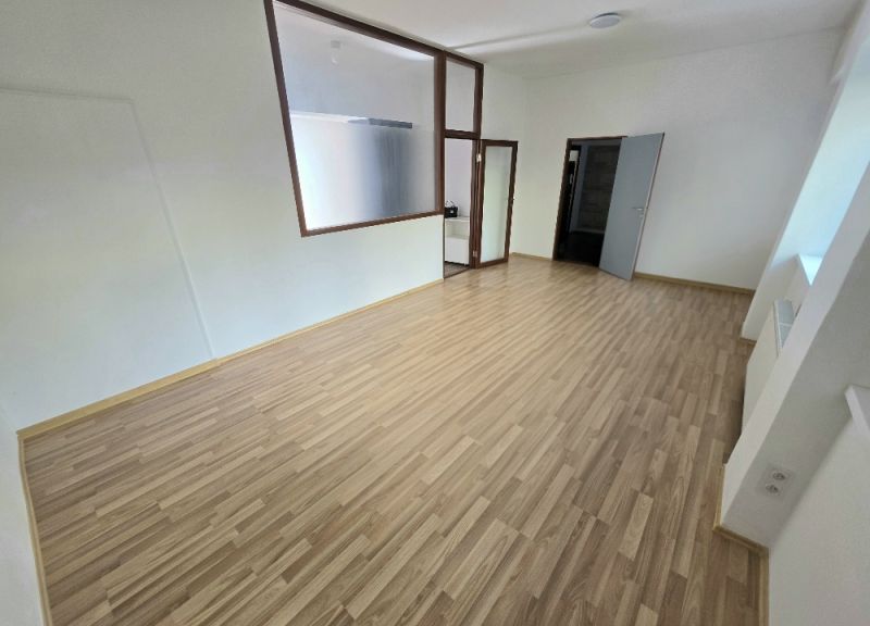 PRENÁJOM Bánovce nad Bebravou/2 IZBOVÝ BYT/CENTRUM-STRED/70m2 - Svetlá miestnosť s podlahou s dreveným dekorom v 2-izbovom byte.
