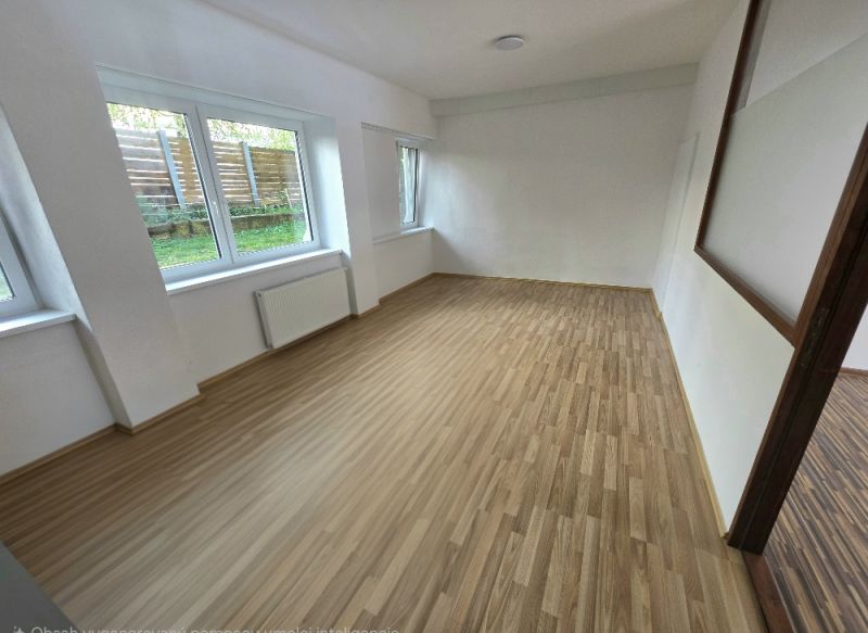 PRENÁJOM Bánovce nad Bebravou/2 IZBOVÝ BYT/CENTRUM-STRED/70m2 - Izba s veľkými oknami a podlahou s dreveným dekorom v 2-izbovom byte.