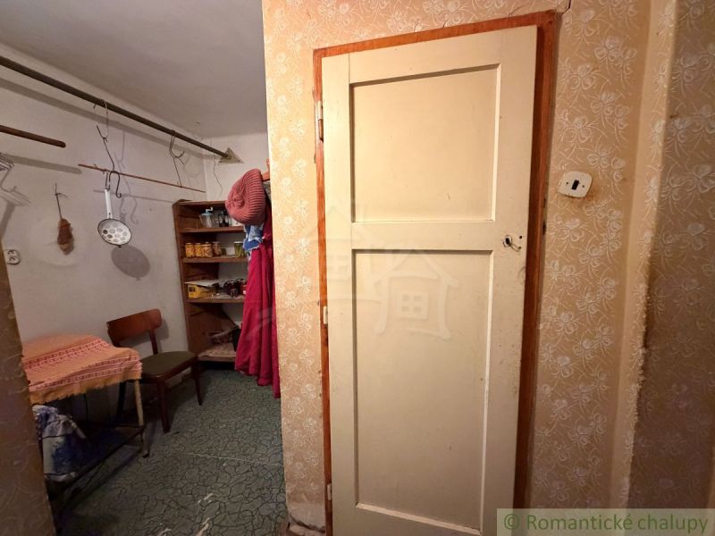 Dom v tichej uličke pri Hurbanove – miesto pre váš vidiecky sen - Interiér rodinného domu s predsieňou, stoličkou a regálmi. Visia tu kuchynské nástroje.