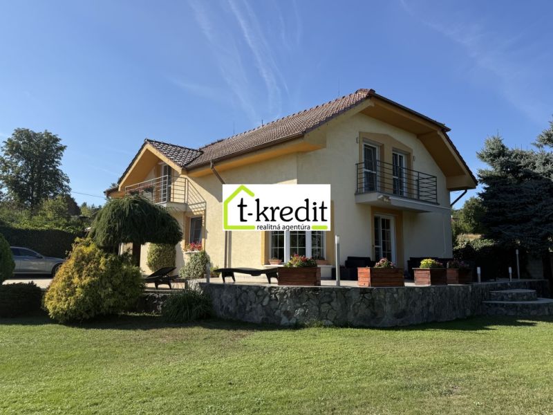 PREDAJ - RODINNÝ DOM - ZLATÉ MORAVCE - Rodinný dom v Zlatých Moravciach, obklopený zeleňou, s kamennou terasou a balkónom.