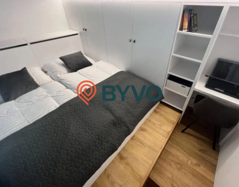 Pekný investičný 1-izb byt 33m2 vedľa Auparku  - Spálňa v 1-izbovom byte s manželskou posteľou a úložným priestorom, podlaha s dreveným dekorom.