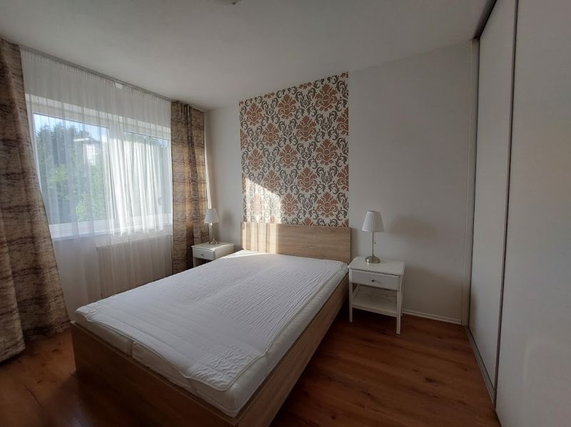 PRENÁJOM : MODERNÝ 3 IZBOVÝ BYT S TERASOU A GARÁŽOVÝM STÁTÍM, BELVEDER - Spálňa s posteľou, tapetou a podlahou s dreveným dekorom v 3-izbovom byte.