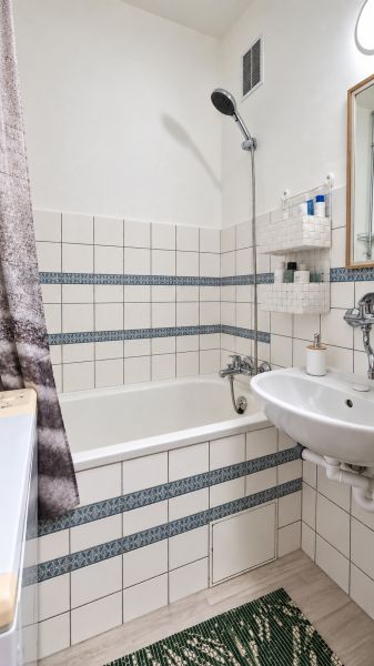 3-izbový byt v centre Pezinka, balkón, výťah, pivnica, komora - Kúpeľňa s vaňou, umývadlom, bielym obkladom a vzorovanými detailmi v 3-izbovom byte.