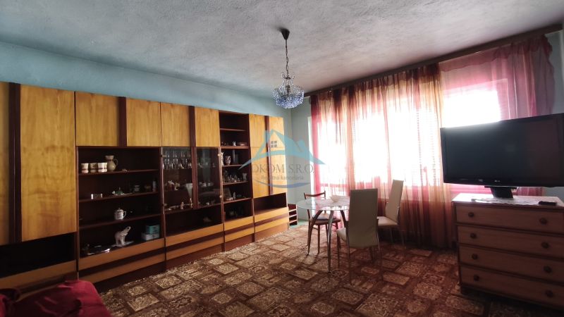 MIMORIADNE ZNÍŽENÁ CENA! Priestranný 6-izbový RD, Nenince, V. Krtíš. - Obývacia izba v rodinnom dome s vitrínou, jedálenským stolom a televíziou.