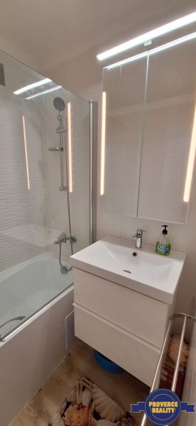REZERVOVANÉ: 3 izbový byt + 2x balkón, komplet.rekonštr. - KOMÁRNO - Kúpeľňa v 3-izbovom byte s vaňou, zrkadlovou skrinkou a podlahou s dreveným dekorom.