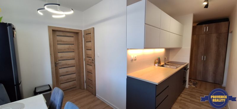 REZERVOVANÉ: 3 izbový byt + 2x balkón, komplet.rekonštr. - KOMÁRNO - Kuchyňa v 3-izbovom byte s podlahou s dreveným dekorom a moderným osvetlením.