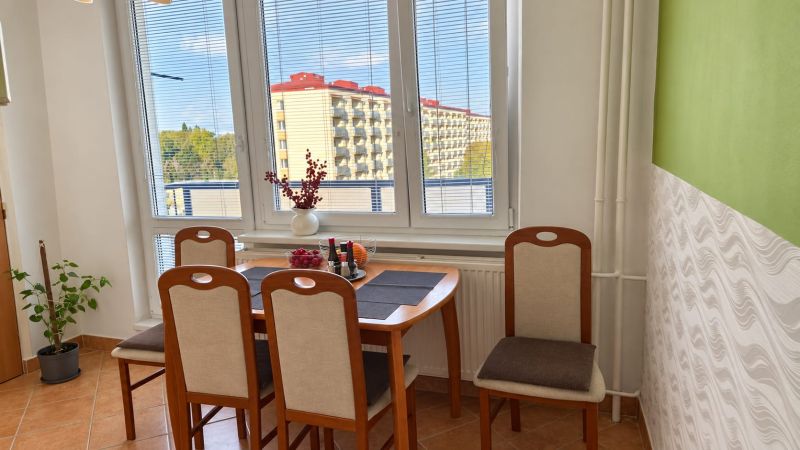 PRENÁJOM | 3-IZBOVÝ BYT | 80 m² | 2 BALKÓNY | ZARIADENÝ | CENTRUM I  - Jedálenský kút s drevenými stoličkami a oknom v 3-izbovom byte.