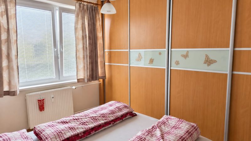 PRENÁJOM | 3-IZBOVÝ BYT | 80 m² | 2 BALKÓNY | ZARIADENÝ | CENTRUM I  - Spálňa v 3-izbovom byte s vstavanou skriňou a posteľou s červeným povlečením.