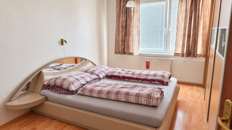 PRENÁJOM | 3-IZBOVÝ BYT | 80 m² | 2 BALKÓNY | ZARIADENÝ | CENTRUM I  - Spálňa v 3-izbovom byte s posteľou, skrinkou pod zrkadlom a podlahou s dreveným dekorom.