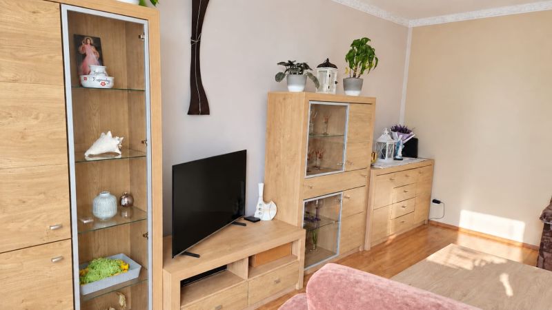 PRENÁJOM | 3-IZBOVÝ BYT | 80 m² | 2 BALKÓNY | ZARIADENÝ | CENTRUM I  - Obývacia izba s nábytkom z dreva, dekoratívnymi kvetmi a podlahou s dreveným dekorom.