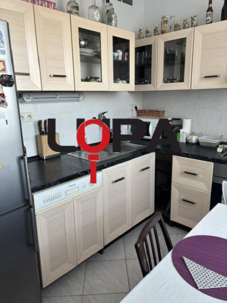 PREDAJ  2 izb. bytu s balkónom v Komárne - Kuchyňa v 2-izbovom byte s dreveným dekórom nábytku a svetlými obkladačkami.