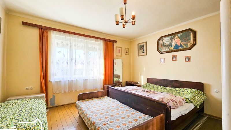 PREDAJ - 4 izbový rodinný dom, Kráľov Brod - Spálňa v rodinnom dome s posteľou, závesmi a dekoráciami na stenách.