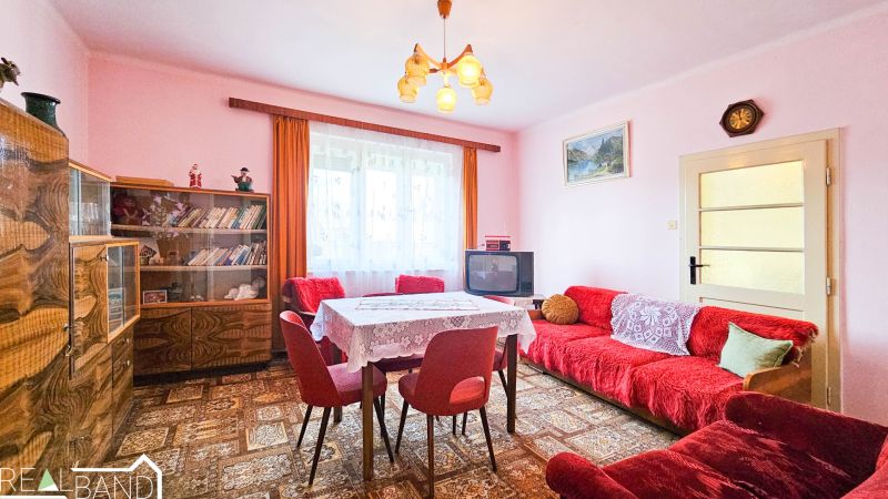 PREDAJ - 4 izbový rodinný dom, Kráľov Brod - Svetlá izba v rodinnom dome s retro nábytkom, kobercom a dekoráciami.